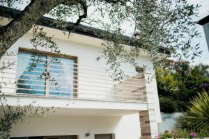 uma casa branca com varanda e árvores em Casa Chiara em Gardone Riviera