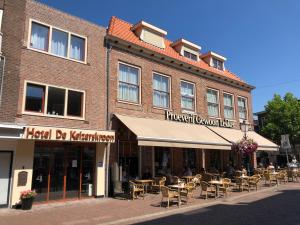 a brick building with tables and chairs in front of it at Hotel de Keizerskroon Hoorn in Hoorn