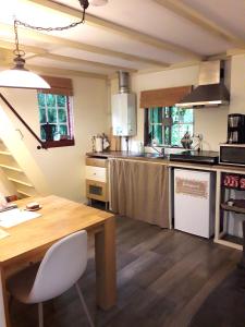 eine Küche mit einem Holztisch und einer Arbeitsplatte in der Unterkunft Het Vogelhuisje in Twijzelerheide