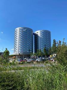 two tall buildings in front of a parking lot at Hotel de Keizerskroon Amsterdam-Schiphol-Halfweg in Halfweg