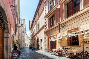 Un callejón con mesas y sillas en una calle en Balestrari Palace close to Campo dei Fiori Piazza Navona Piazza Venezia, en Roma
