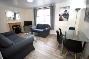 a living room filled with furniture and a tv at Lochend Serviced Apartments in Edinburgh