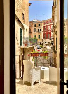 a balcony with chairs and a view of a city at San Michele delle grotte BnB in Gravina in Puglia