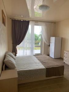 a bedroom with a bed and a window with a refrigerator at ZAKAT in Zatoka