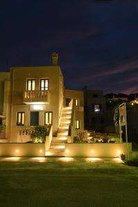a building with stairs and lights at night at RODAVGI APARTMENTS in Andros