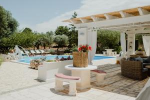 a patio with a table and chairs next to a pool at Antica Tenuta dei Trulli in Alberobello