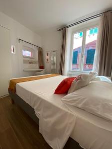 a bedroom with a white bed with two red pillows at Carruggio 151-1 in Sestri Levante