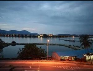 Marina Height Seaview Resort, Teluk Batik, Lumut في Kampong Tebing Rabak: منظر على كمية كبيرة من الماء في الليل