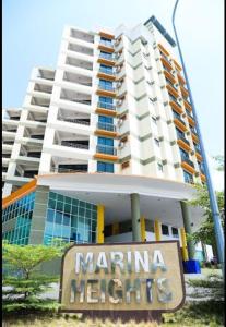Marina Height Seaview Resort, Teluk Batik, Lumut في Kampong Tebing Rabak: مبنى كبير امامه لافته