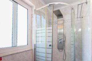 アギオス・ゴルディオスにあるKadith Apartmentsのバスルーム(ガラスドア付きのシャワー付)