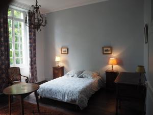1 dormitorio con cama, mesa y ventana en Gentilhommière de Lurcy le Bourg, en Lurcy-le-Bourg