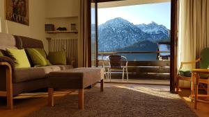 a living room with a couch and a view of a mountain at Ferienwohnung Halder, Ihr Bett im Allgäu in Bad Hindelang