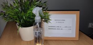 a bottle sitting next to a potted plant and a card at Apartament w Oliwie in Gdańsk