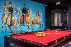 Cette chambre dispose d'un billard avec des chevaux sur le mur. dans l'établissement Mercure Bords de Loire Saumur, à Saumur