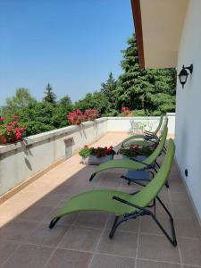 a group of green chairs sitting on a balcony at La Quercia in Badia Calavena