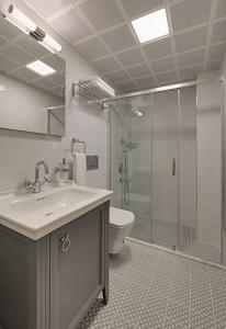 a bathroom with a toilet and a sink and a shower at Atrium Taş Otel in Cesme