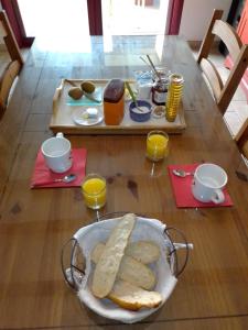 una mesa con un tazón de pan y dos vasos de zumo de naranja en Lastalia, en Ilharre