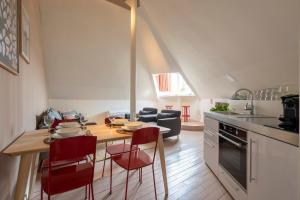 una cucina con tavolo e sedie rosse in una stanza di SHWAY - The Suit ad Anversa