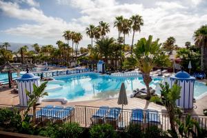 een zwembad in een resort met stoelen en palmbomen bij Caybeach Princess in Maspalomas