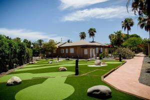 einen Golfplatz mit Felsen und ein Haus in der Unterkunft Caybeach Princess in Maspalomas