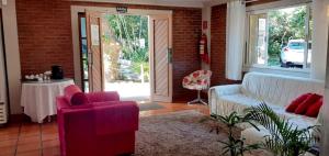 een woonkamer met een bank, stoelen en een tafel bij Pousada Pomar De Manguinhos in Manguinhos