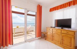 sala de estar con TV y puerta corredera de cristal en Villa Buraux, en Roses