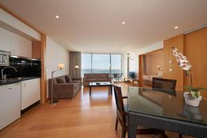 a kitchen and living room with a table and a couch at Golden Residence Hotel in Funchal