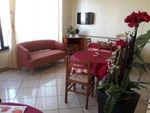 ein Wohnzimmer mit einem Tisch und einem Sofa in der Unterkunft Hotel Villa Aurora in Bellaria-Igea Marina