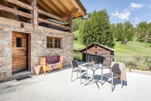 采尔马特Mountain Chalet 4 You的建筑物前有桌椅的露台