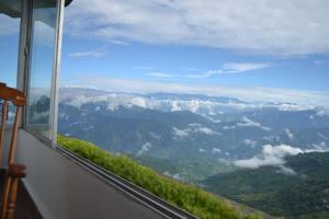 een uitzicht op een vallei vanuit een raam van een berg bij The Retreat in Darjeeling