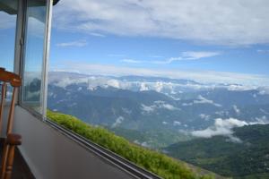 a view of a valley from a window of a mountain at The Retreat in Darjeeling