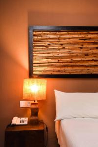 1 dormitorio con cama, lámpara y teléfono en Chillout Hotel Tres Mares, en Tarifa