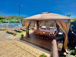 a wooden deck with a table and chairs under an umbrella at Iorga's House in Eforie Nord