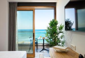 a bedroom with a view of the ocean at North Coast Seaside Suites in Rethymno Town