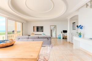 een woonkamer met een bank en een tafel bij Villa piscine avec magnifique vue mer panoramique in Biot