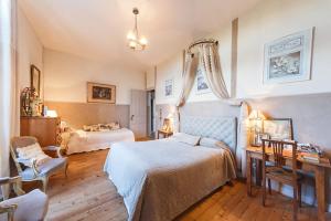 1 Schlafzimmer mit 2 Betten, einem Tisch und einem Schreibtisch in der Unterkunft Chateau De La Moriniere in Beaupréau