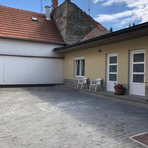 para krzeseł siedzących przed domem w obiekcie Avas Apartman w Miszkolcu