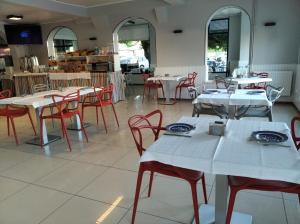 a restaurant with white tables and red chairs at Hotel Miramar Playa America Nigran in Nigrán