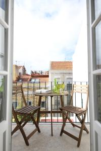 a table and two chairs on a balcony at The Lookout Duplex - Bairro Alto in Lisbon