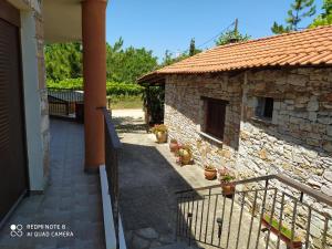 - Vistas al exterior de un edificio de piedra con porche en Morfili Villa en Limenaria