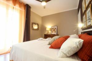 um quarto com uma cama branca com almofadas laranja e branca em La maison du monde em Bordighera