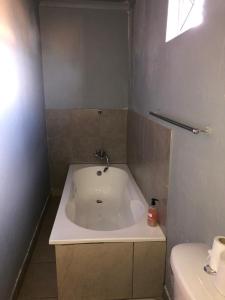 y baño con bañera y lavamanos. en FGM Guesthouse 2, en Alberton