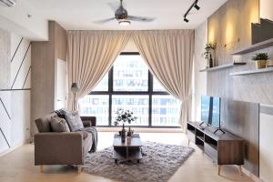 Dsara Sentral New Design unit 2 bedroom في شاه عالم: غرفة معيشة مع أريكة ونافذة كبيرة