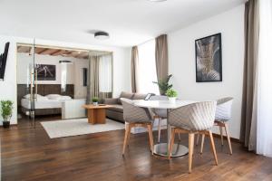 a living room with a table and chairs and a couch at DAREBELL – Designerapartments Sporgasse in Graz
