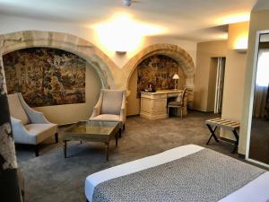 a hotel room with a bed and a desk and chairs at Hôtel des Augustins in Aix-en-Provence