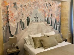 a bedroom with a bed with a painting on the wall at Hôtel des Augustins in Aix-en-Provence