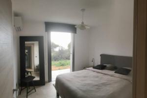 una camera da letto con un letto e una grande finestra di Villa Fogata à l'Ile Rousse vue mer exceptionnelle a LʼÎle-Rousse