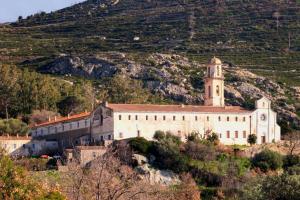 un edificio sul fianco di una collina con una torre dell'orologio di Villa Fogata à l'Ile Rousse vue mer exceptionnelle a LʼÎle-Rousse
