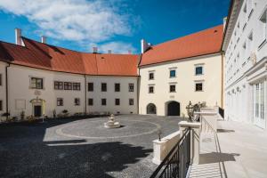 a large white building with a red roof at Palace Art Hotel Pezinok in Pezinok