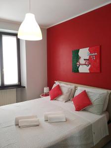 a bedroom with a large white bed with red walls at Nel cuore di Stresa in Stresa